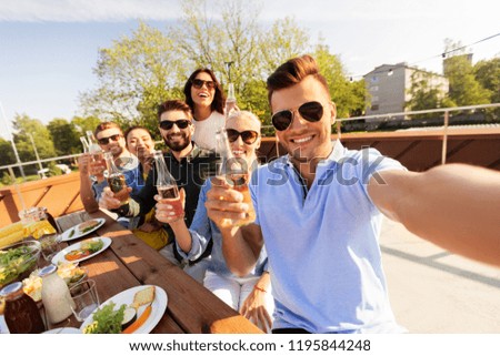 leisure and people concept - happy friends having bbq party on rooftop in summer and taking selfie