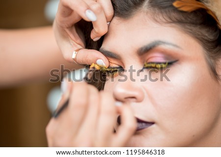 Halloween. Portrait of young beautiful girl with make-up skeleton on her face. creative yellow make-up. Makeup artist paints lips