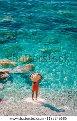 young woman walking at pebble beach Monterosso on vacation Cinque terre Monterosso al Mare pebble beach Cinque Terre, Italy  Royalty-Free Stock Photo #1195846585