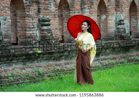 Portrait of Young Thai beautiful woman in traditional Thai dress/costume is walking in the ancient city of Ayutthaya , Thailand