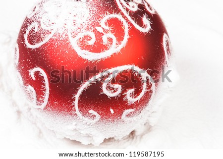 red decorated bauble with  snow on white background