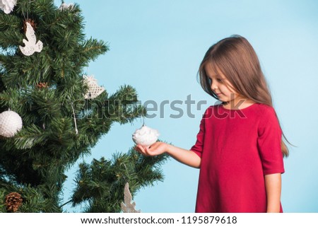 Little girl with christmas tree on blue background