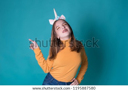 Kawaii teenage girl. Cute young woman with unicorn horn and braces on blue background. Colorful makeup.