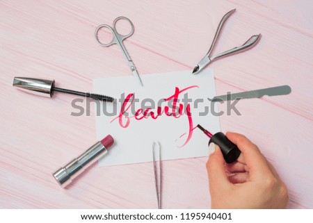 Beauty text. Font of lettering word on white paper with red ink by calligrapher. Cosmetic products frame. Graphic design, handwriting, lettering, concept.