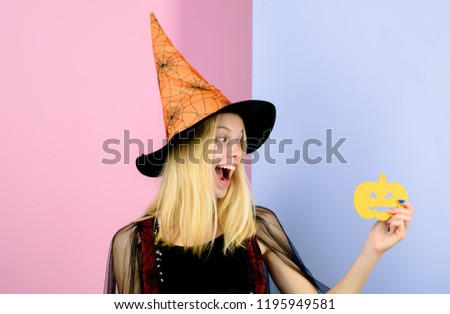 Halloween, carnival, masquerade, fairytale theme. Halloween happy witch with magic Pumpkin. Paper jack-o-lantern. Beautiful woman in witch hat hold Halloween symbol paper pumpkin. Halloween art design