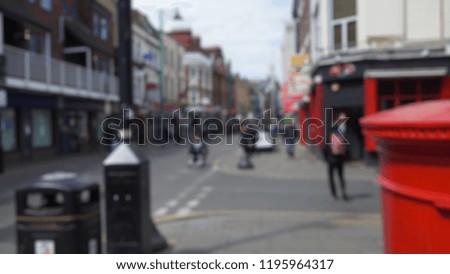 Blurred sidewalk view of street in London, England with pedestrians