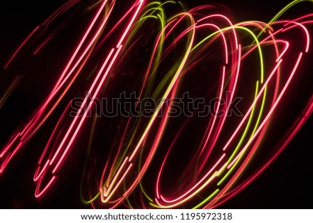 Overlaying wavy lines forming an abstract pattern on a dark background. Long exposure light background. Toned