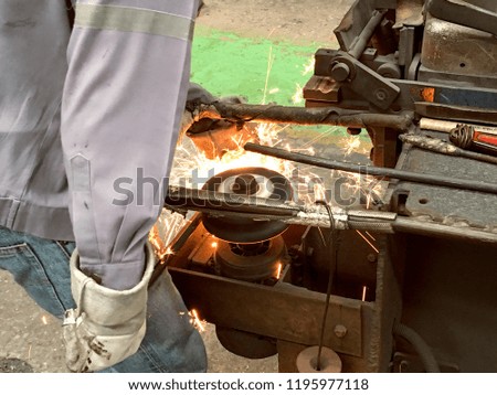 Man is grinding steel wire in factory, Worker work in construction site, Flash of fire from grinding stone, Metal industry, Operator working in the site, Workplace,  steel structures manufacture works