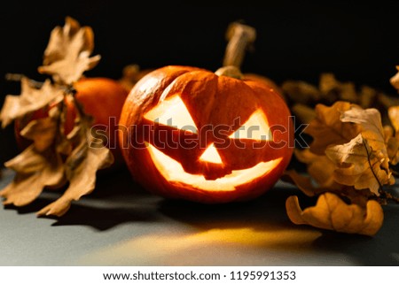 Halloween pumpkin ghost lantern with candles lit inside.