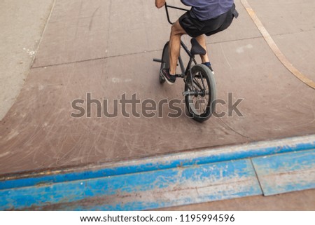 rear view of BMX biker in skate Park in open air, people skills with special bike