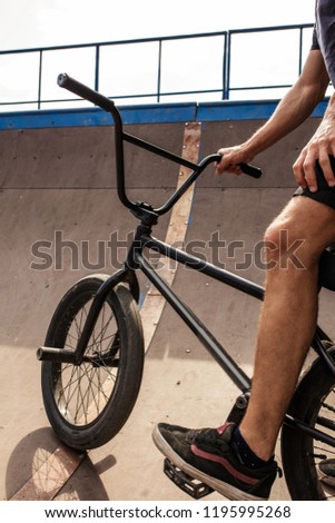Close-up view of legs on bmx bike for tricks, teenager rides