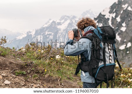 young tourist photographing the amazing landscape. back view photo. holiday, digital cmara, technology concept