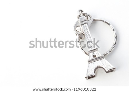 Key chain in the shape of Eiffel Tower on white background, European holiday ideas