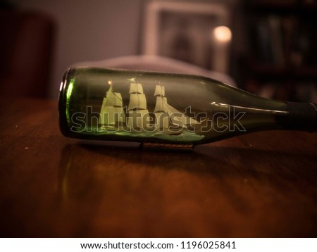 A close-up of a vintage green ship in a bottle from the 1960s against a brown wooden table
