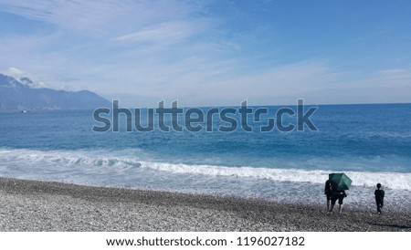 blue ocean wave on stone beach. blue sky background.