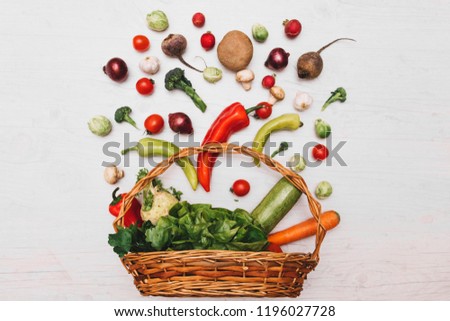 Healthy food in basket. Studio photography of different fruits and vegetables isoleted on white backdrop, top view.