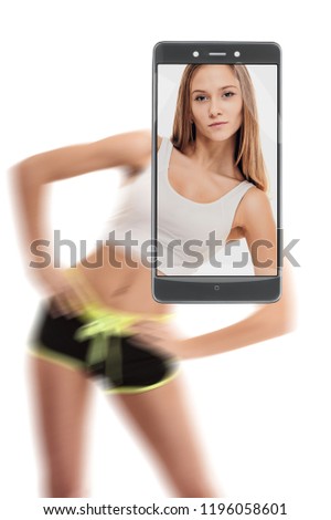 Fit athletic woman stretching her muscular body. conceptual image with a smartphone, demonstration of device capabilities