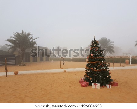 Christmas tree with decorations at the Desert camp in a foggy morning of Arabian Gulf. 