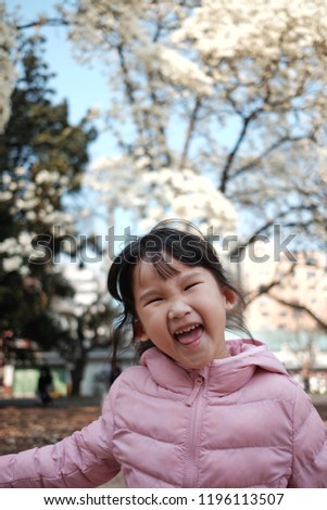 Asian little girl is laughing in the garden, winter