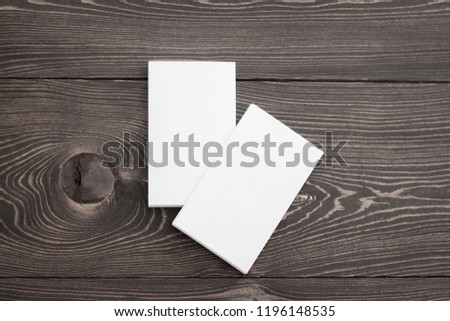 Closeup mockup of two white business cards stacks at brown wood background. Template for branding identity. 
