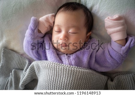 Newborn baby sleeping 4 weeks old in purple Royalty-Free Stock Photo #1196148913