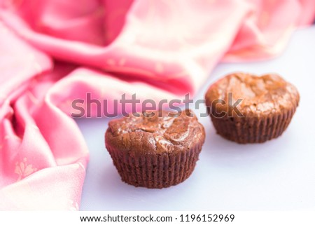 A couple of brownies against a light pink themed background