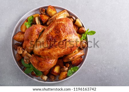 Roast chicken with roast potatoes and mushrooms on plate Royalty-Free Stock Photo #1196163742