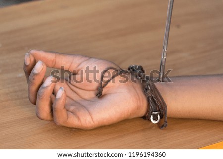 Closeup shot of Boy trying to open his hand with screwdriver