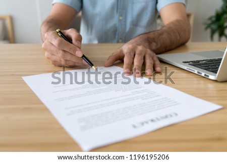 Man signing contract putting signature on official legal document making purchase, close up focused on pen and paper. Prenuptial agreement or buying selling. Human resources and employment concept