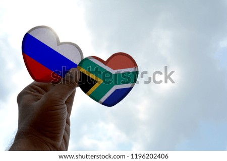 Hand holds a heart Shape Russia and South Africa flag, love between two countries