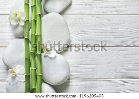 Flat lay composition with green bamboo stems on wooden background. Space for text