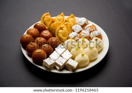 Indian sweets in a plate includes Gulab Jamun, Rasgulla, kaju katli, morichoor / Bundi Laddu, Gujiya or Karanji for diwali celebration Royalty-Free Stock Photo #1196218465