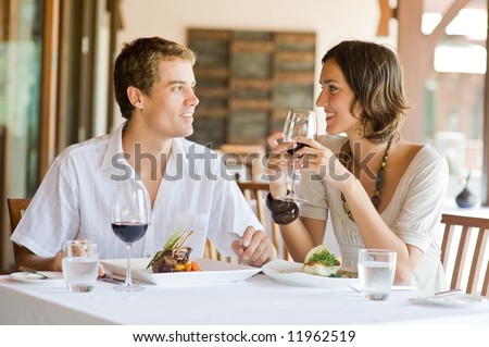 A young couple sitting at a table at an outdoor restaurant Royalty-Free Stock Photo #11962519