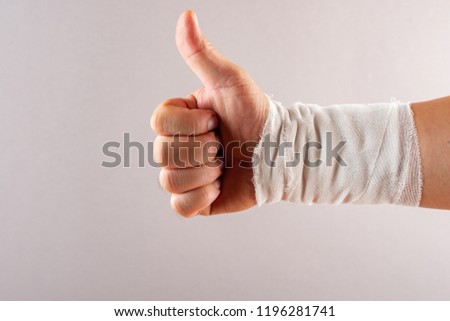 postive gesture of thumbs up by a wrapped hand