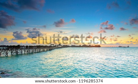 Long bridge heading to beautiful resort at Mabul Island during sunset Royalty-Free Stock Photo #1196285374