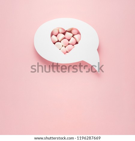 Creative valentines concept photo of comic cloud with heart and candies on pink background.