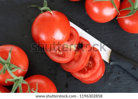 Healthy Food Tomato in Black Stone background with Ceramic knife.
