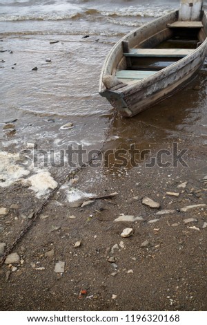 Single wooden boat shore anchored 