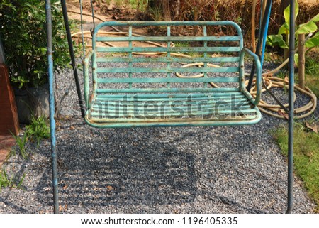 Old-fashioned green iron swing