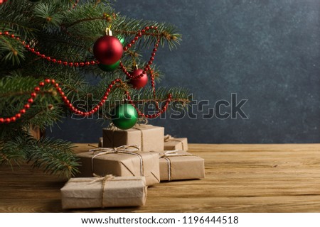 Craft gifts under the tree, on the table, against the wood background. The concept of Christmas and New Year.