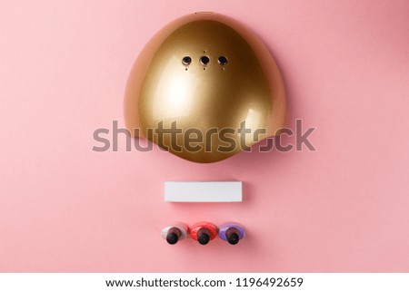 UV lamp lights for nails and set of cosmetic tools for manicure and pedicure on pink background. Top view. Flat lay. Copy space. Minimal creative concept. Pink background in pastel colours