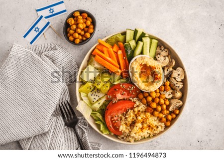 Buddha bowl with vegetables, mushrooms, bulgur, hummus and baked chickpeas. White background, top view. Healthy vegan food concept.