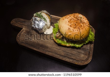 Gourmet hamburger with beef, shrimps and baked potato