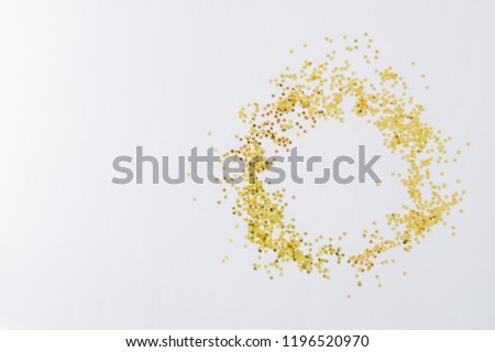 Holiday border with golden christmas confetti on a light background