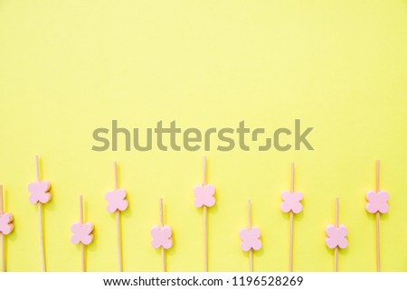 Ecological skewer isolated on yellow background.wooden sticks with flower beads for food decoration. Skewers for the preparation of canapes. Props for snack food.Copy space
