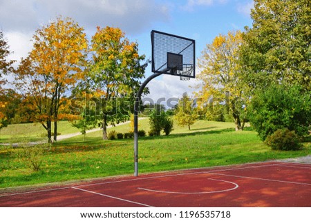 A basketball hoop in a park on a sunny autumn day - city park