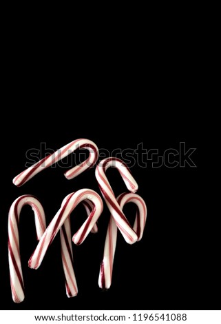Candy canes on black background with copy space