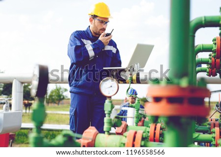 Engineer in an oilfield working with notebook