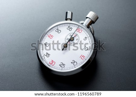 Analogue metal stopwatch on the black background.