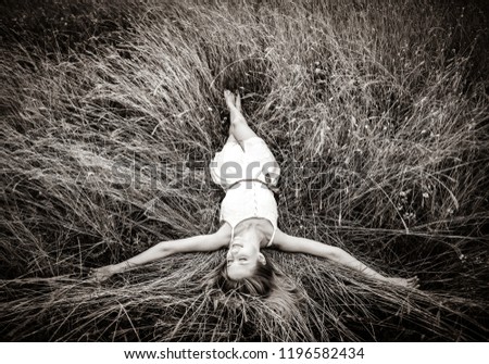 Beautiful girl lying down at grass. Image in black and white style